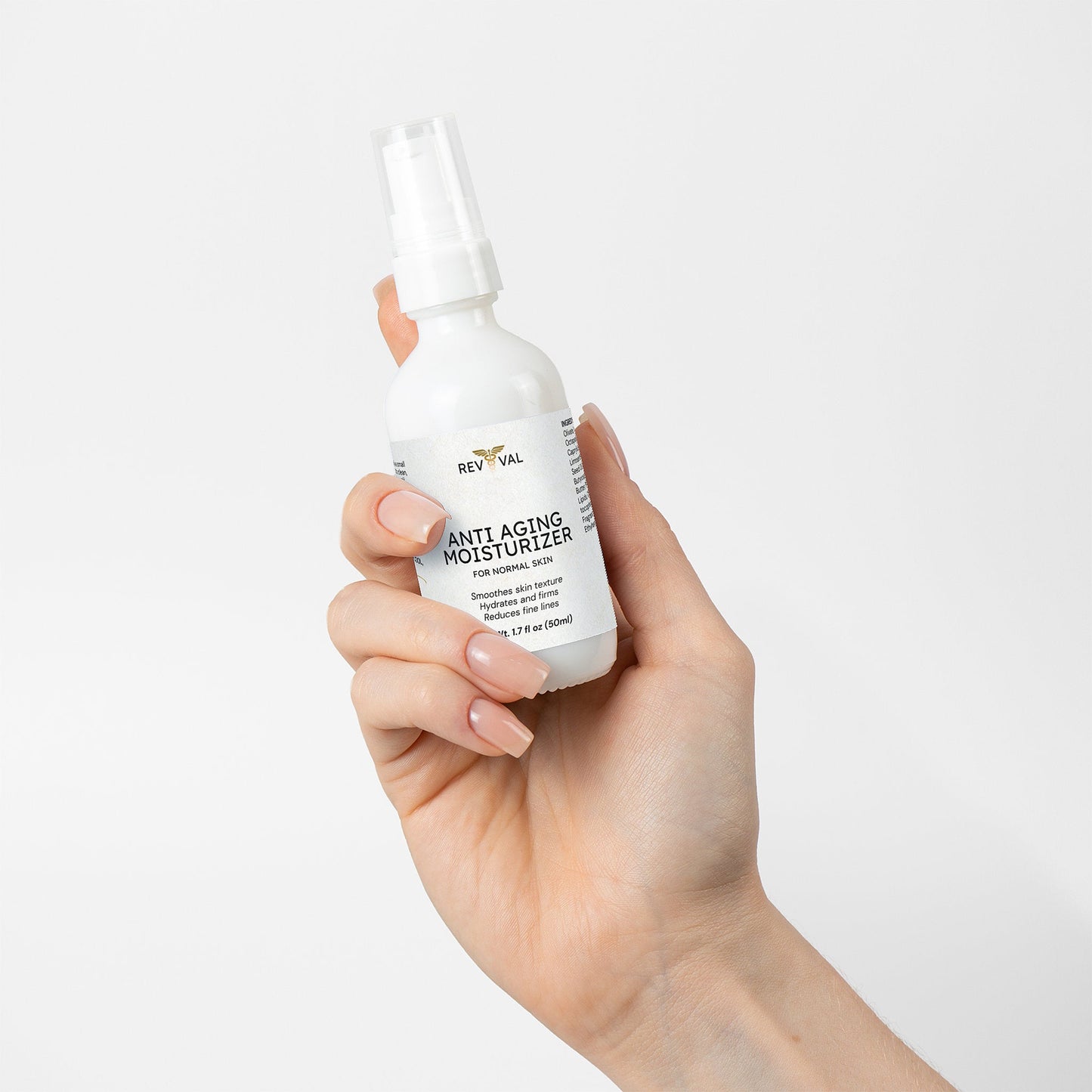 Hand holding a bottle of Reviva Anti-Aging Moisturizer against a white background