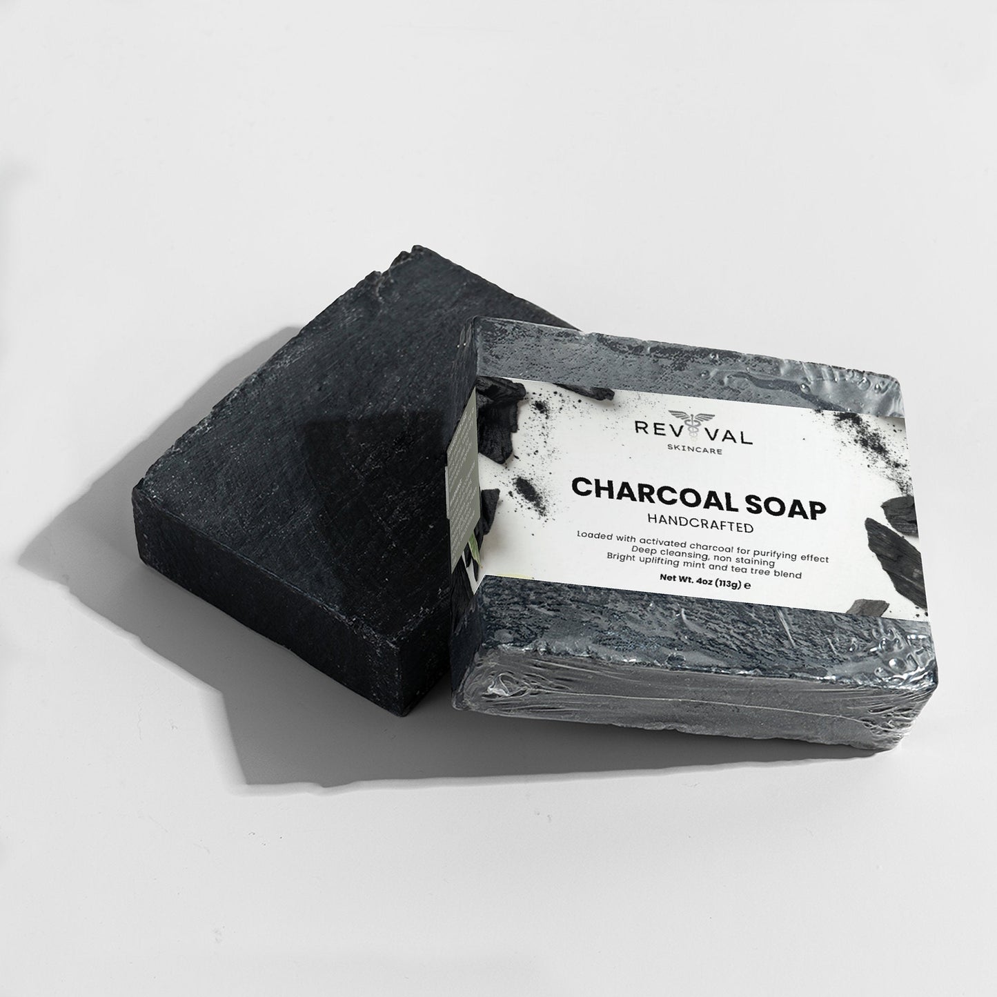 Charcoal soap bar with packaging on a white background