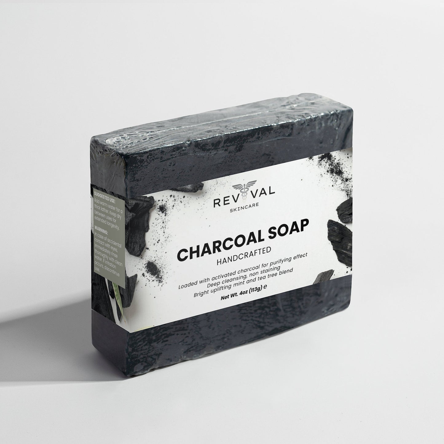 Bar of charcoal soap with Revival Skincare label on a light gray background