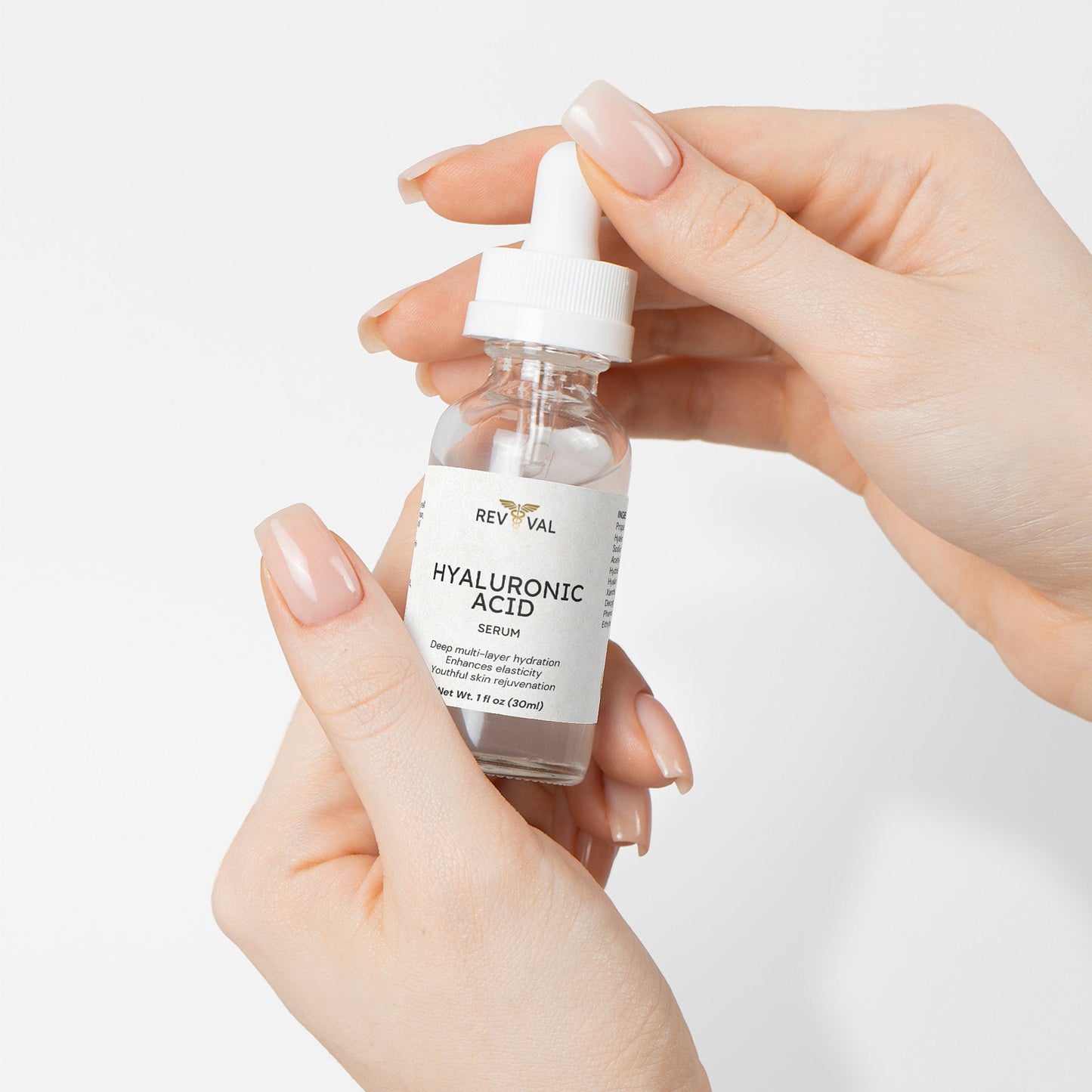 Hand holding a Rev Val Hyaluronic Acid serum bottle against a white background