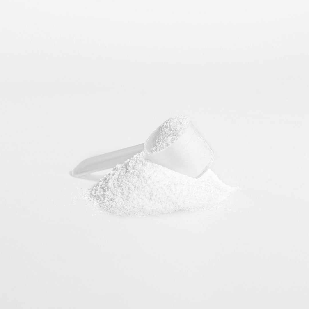 White powder in a measuring spoon on a white background
