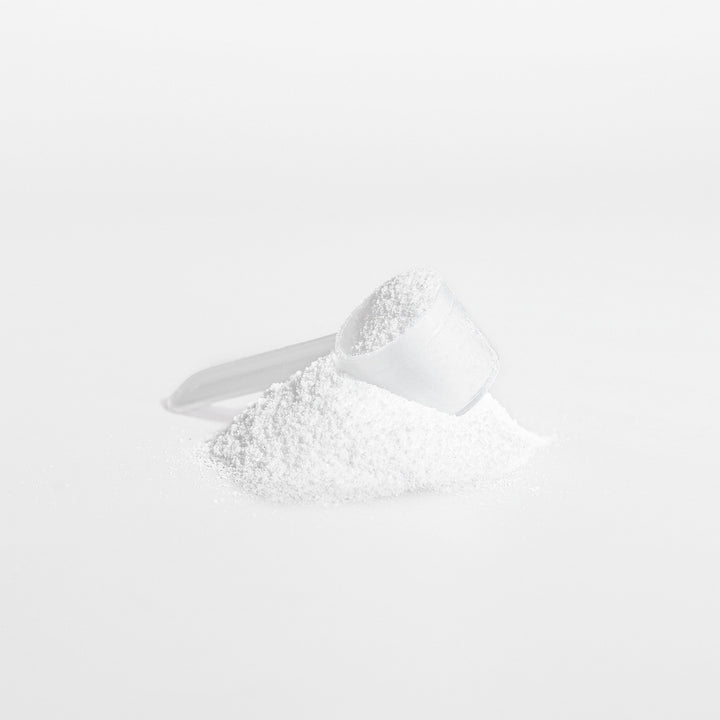 White powder in a measuring spoon on a white background