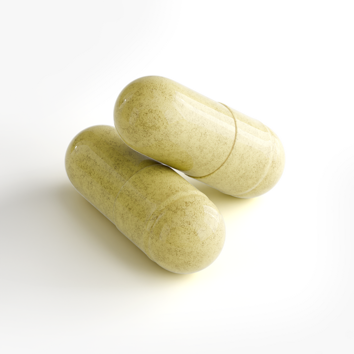 Two pale yellow-green herbal supplement capsules with a speckled texture, resting on a clean white background.