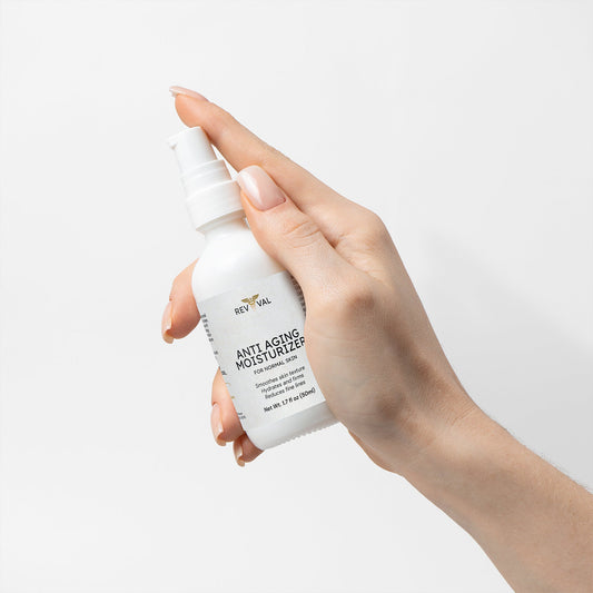 Hand holding a bottle of RevivaL Anti-Aging Moisturizer against a light background