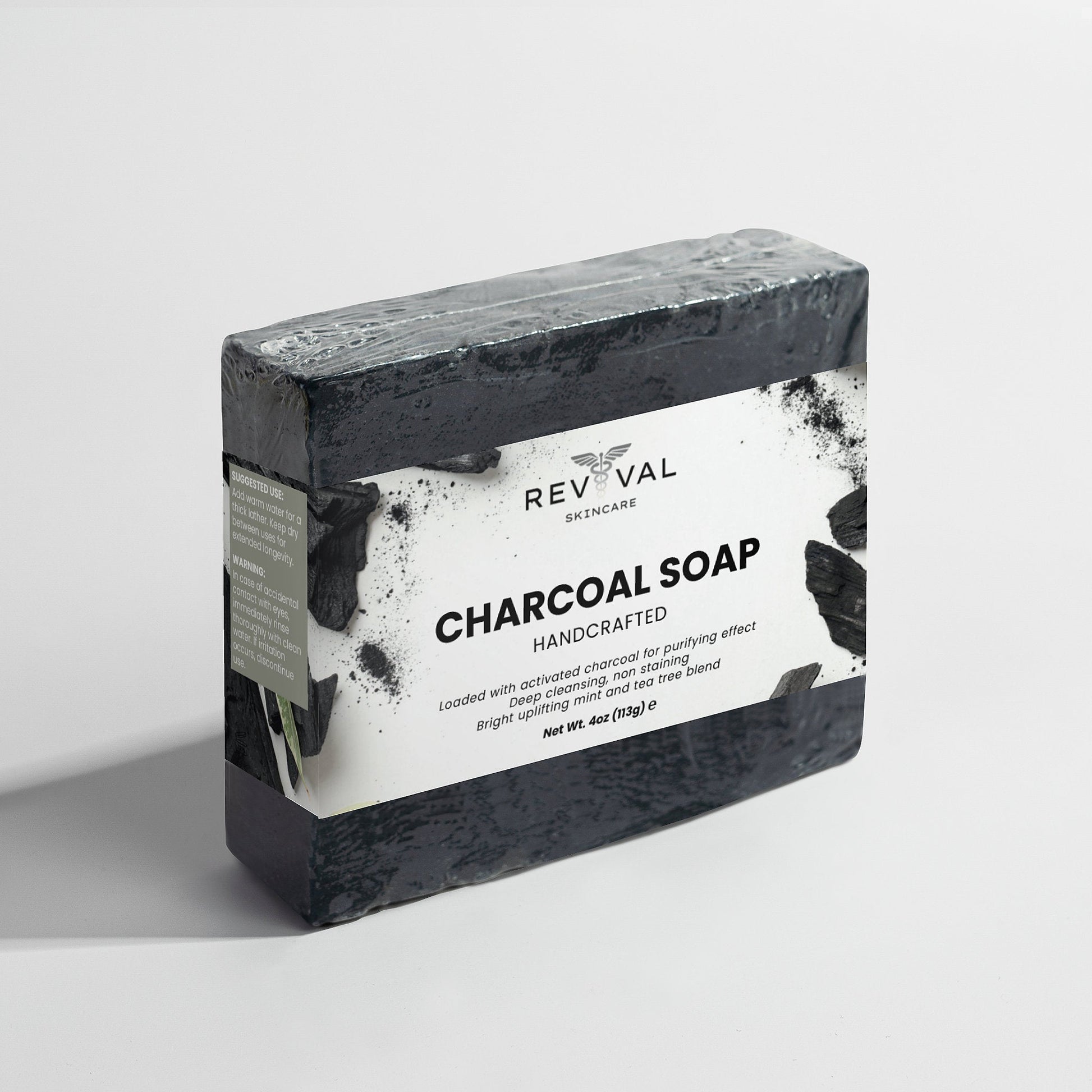 Bar of charcoal soap with Revival Skincare label on a light gray background