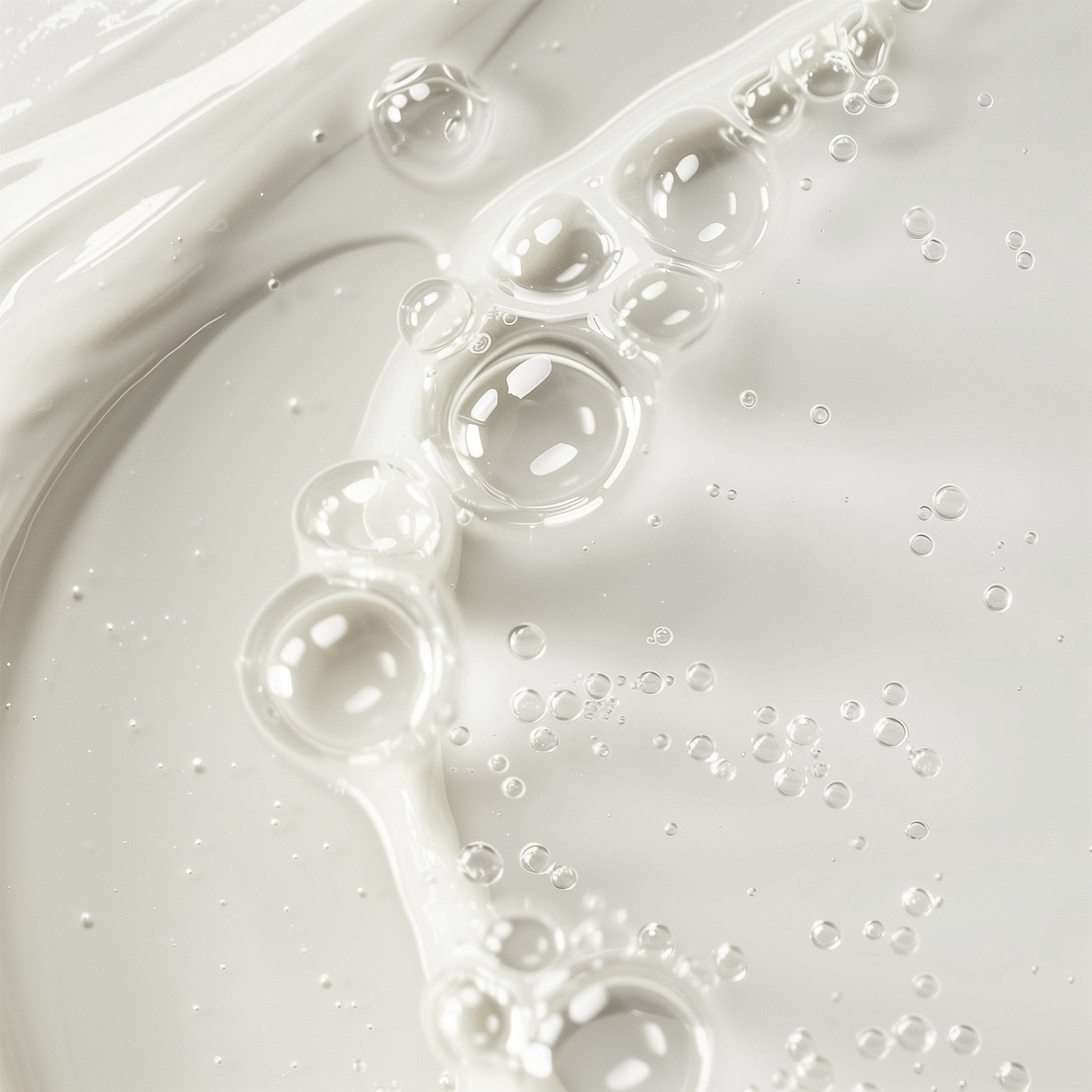 Close-up of white liquid with bubbles on a light gray background