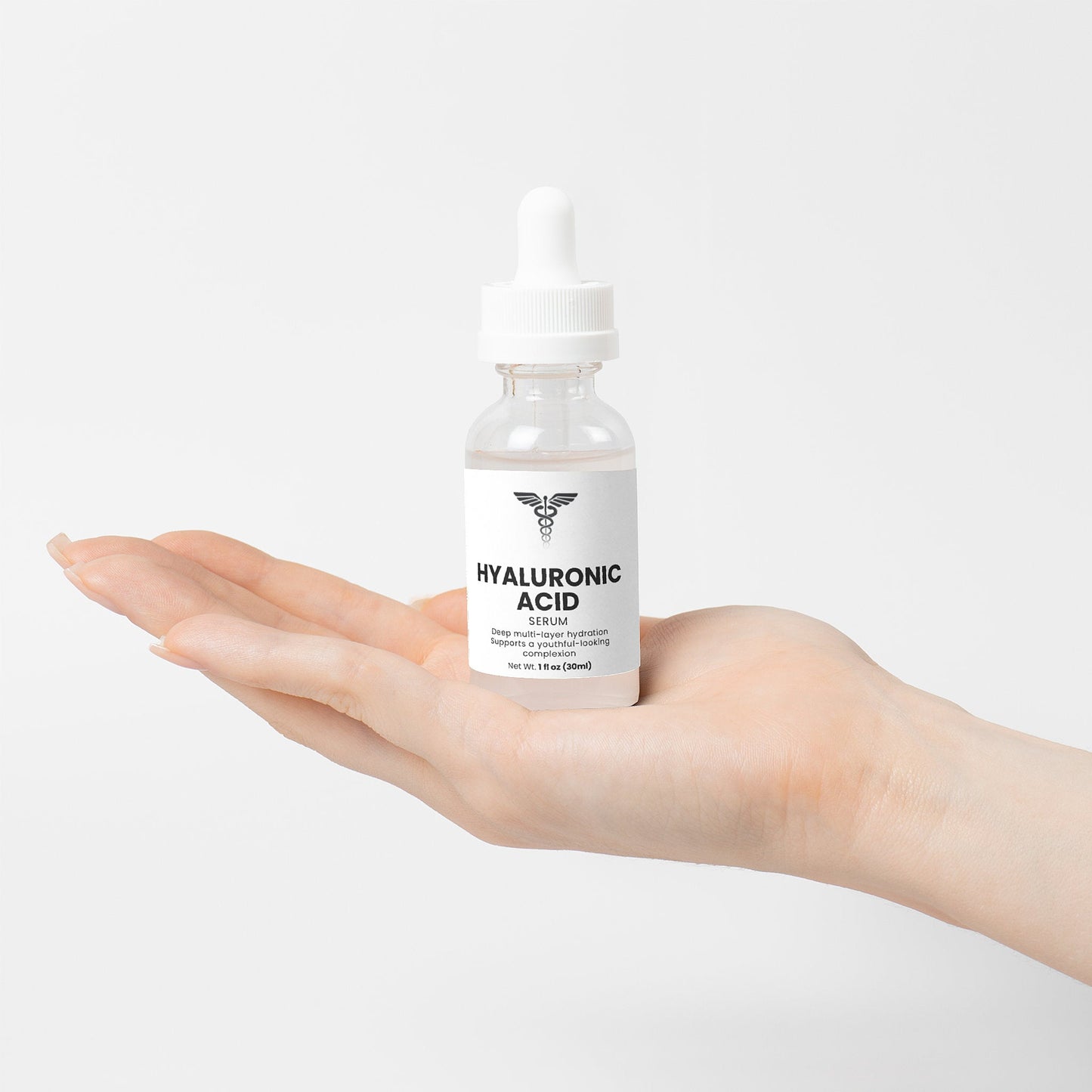 Hand holding a bottle of hyaluronic acid serum against a white background