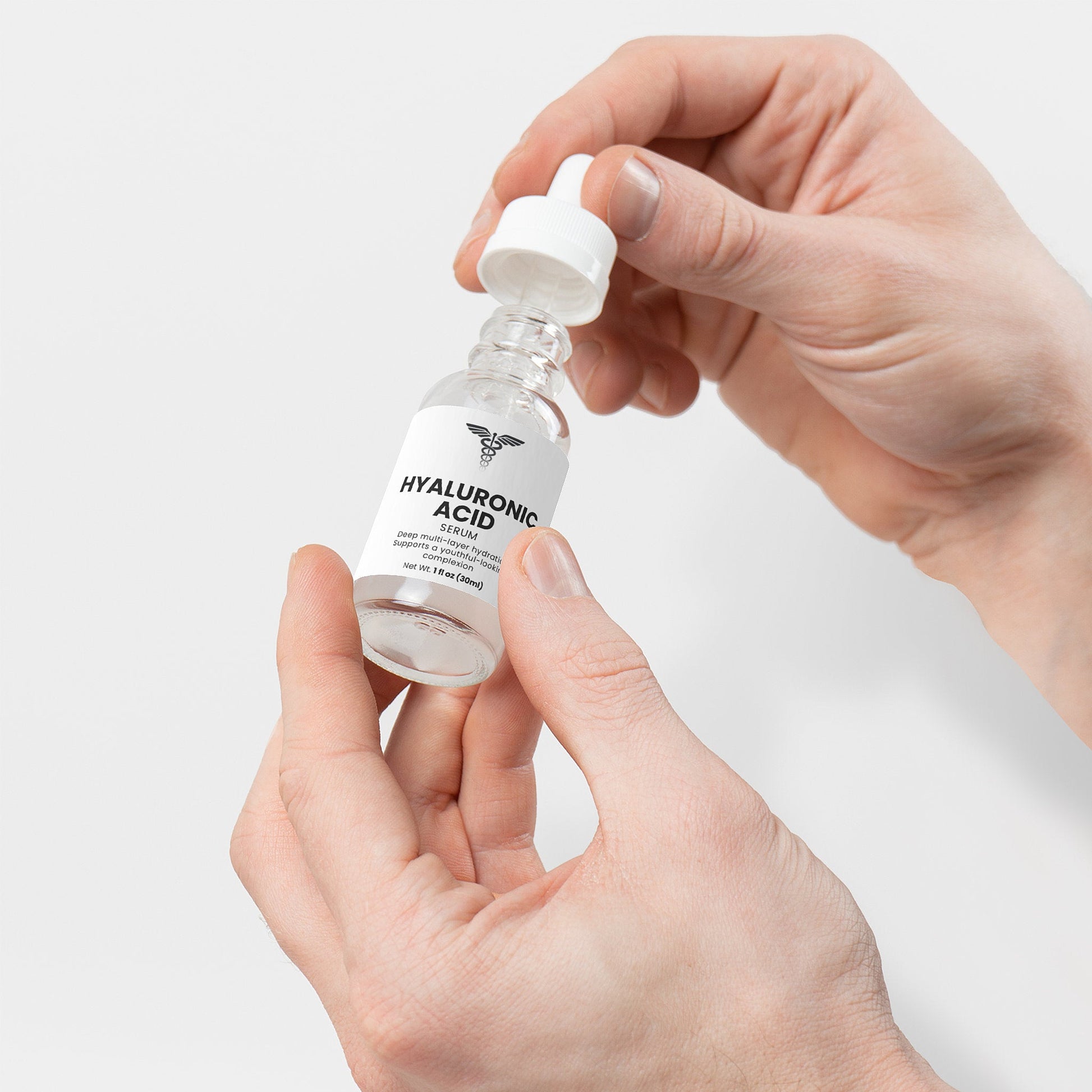 Hand holding a bottle labeled 'Hyaluronic Acid' against a light gray background