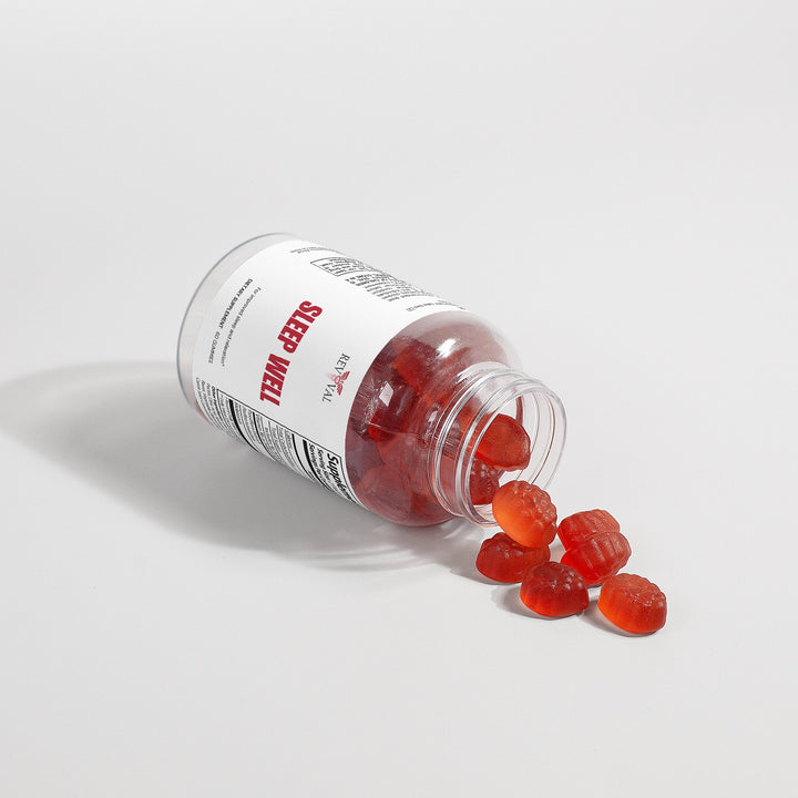 Bottle of gummy supplements with red gummies spilling out on a light gray background