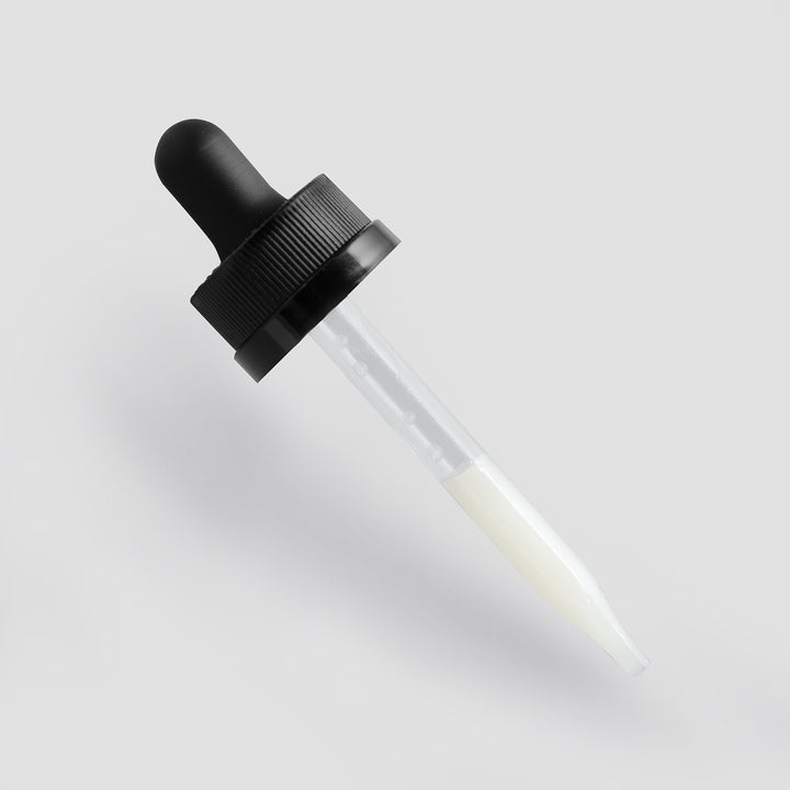 Glass dropper bottle with black cap on a light gray background